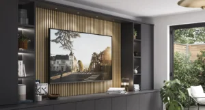 Completed vertical panel media wall in a UK home with charcoal slats and a fireplace