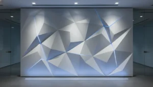 3D geometric corporate media wall with white panels and blue accent lighting File Name: 3d-geometric-media-wall-design.jpg